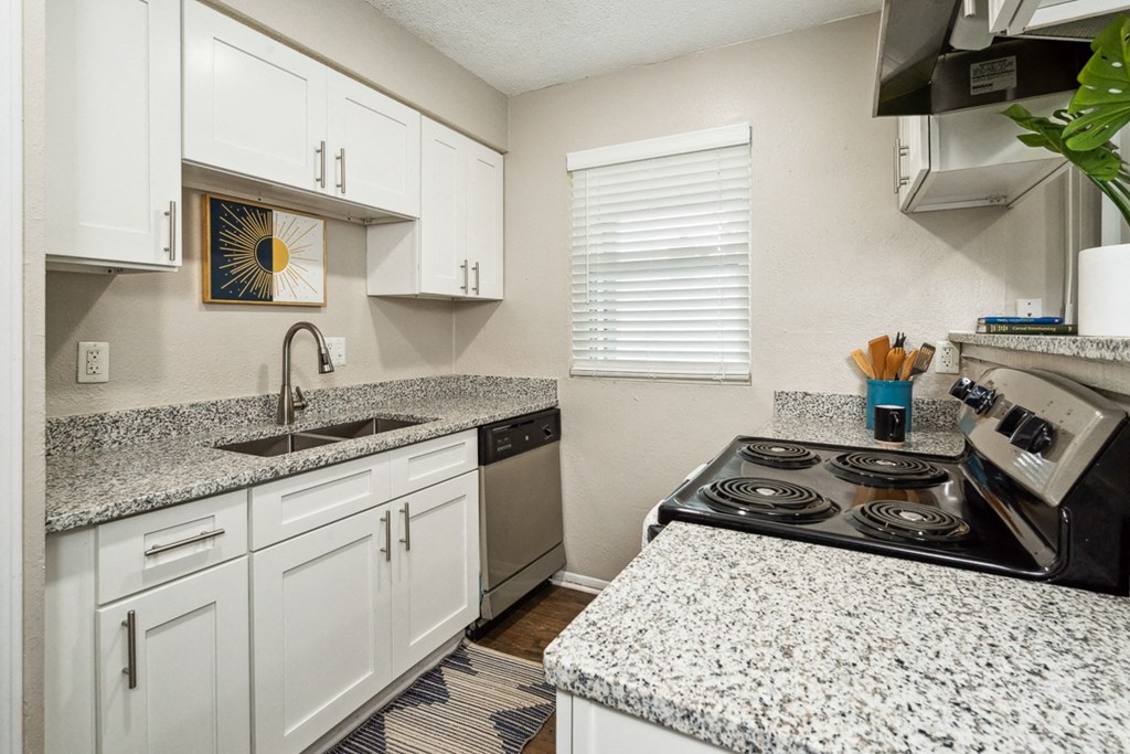 a kitchen with white cabinets and granite countertops