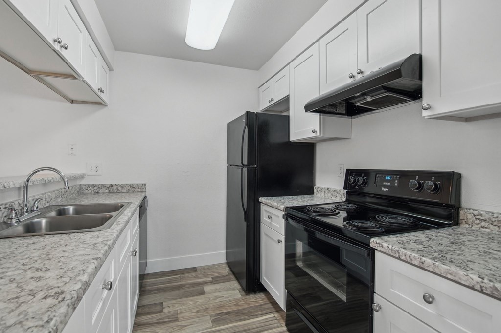 A kitchen with black appliances and white cabinets. at Candela Park Apartments, Arizona, 85201