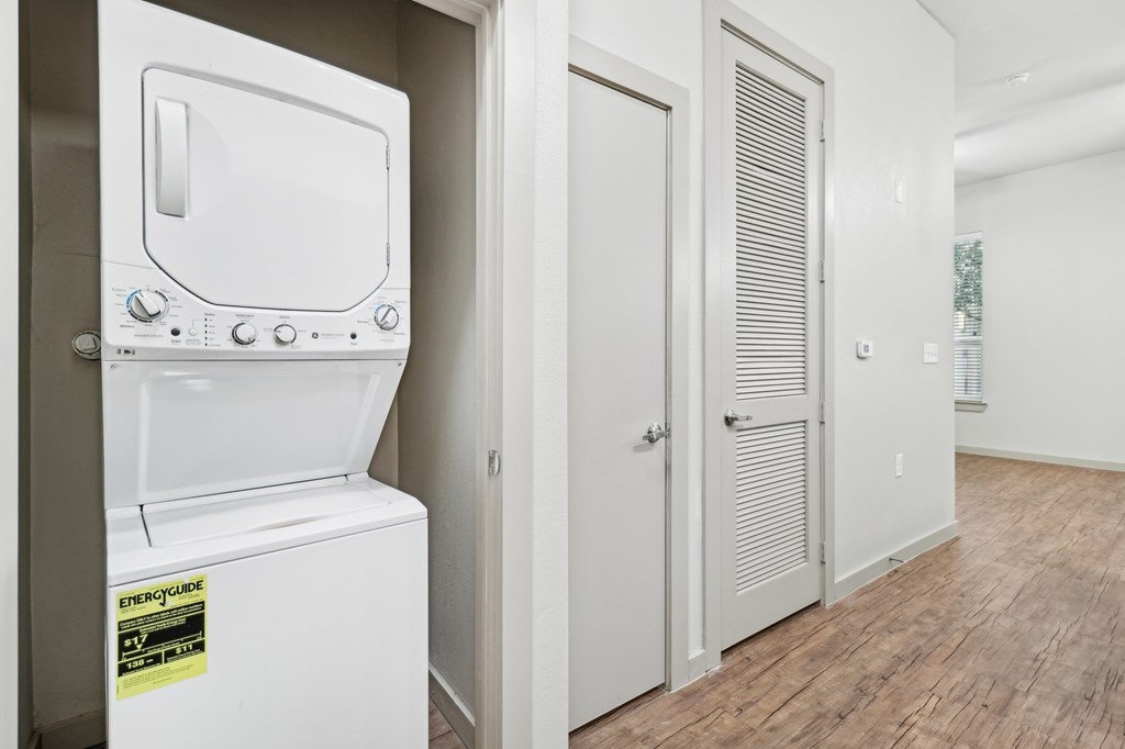 A white tankless water heater with a yellow sticker on it.