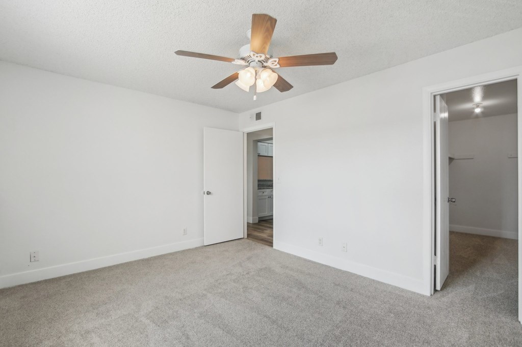 A room with a ceiling fan and carpeted floor at Candela Park Apartments, Mesa, AZ