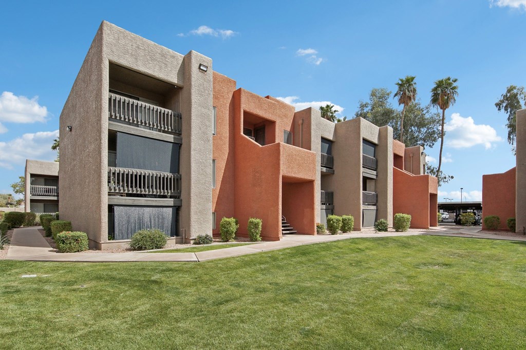A modern building with a red and beige exterior. at Candela Park Apartments, Mesa 85201