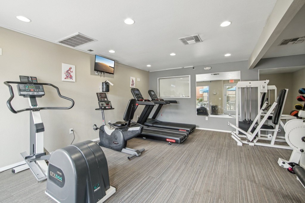 A gym with treadmills, elliptical machines, and other exercise equipment at Candela Park Apartments, Mesa, AZ