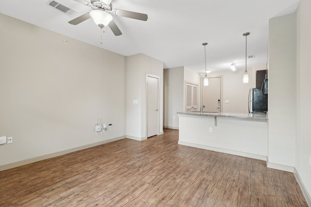 A room with a ceiling fan and wooden flooring.