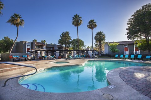 a resort style swimming pool with palm trees in the background