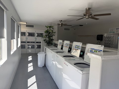 A laundromat with washers and dryers lined up.