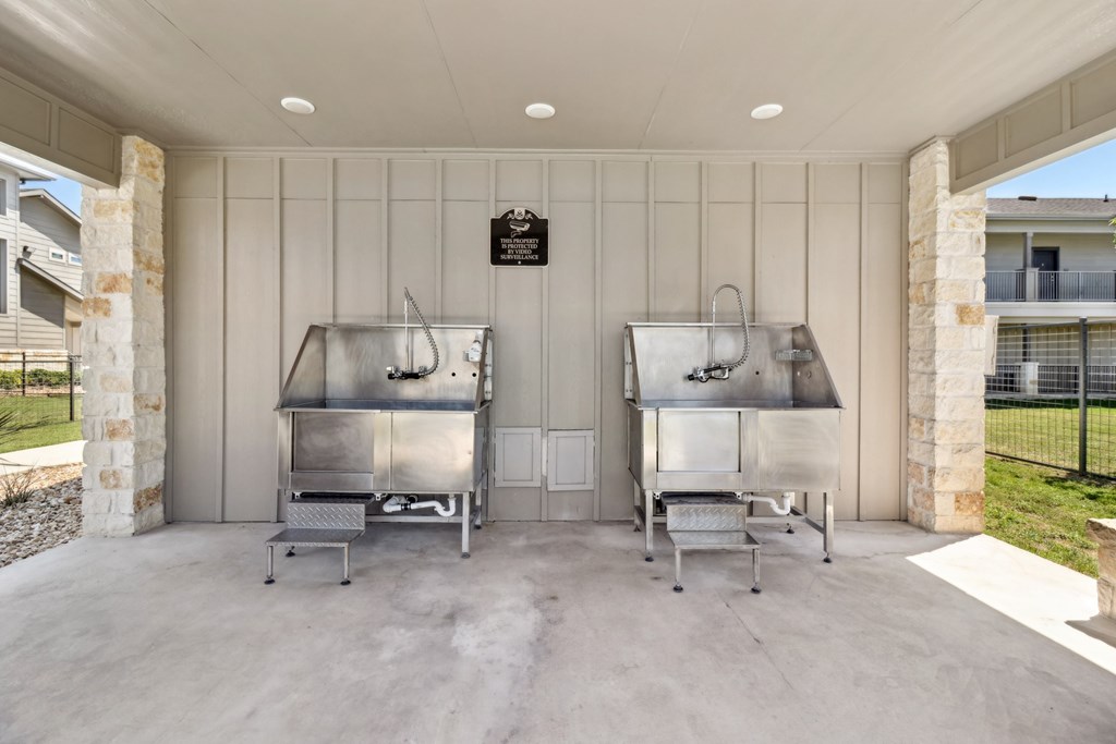 Two large stainless steel ovens are installed in a covered outdoor kitchen.