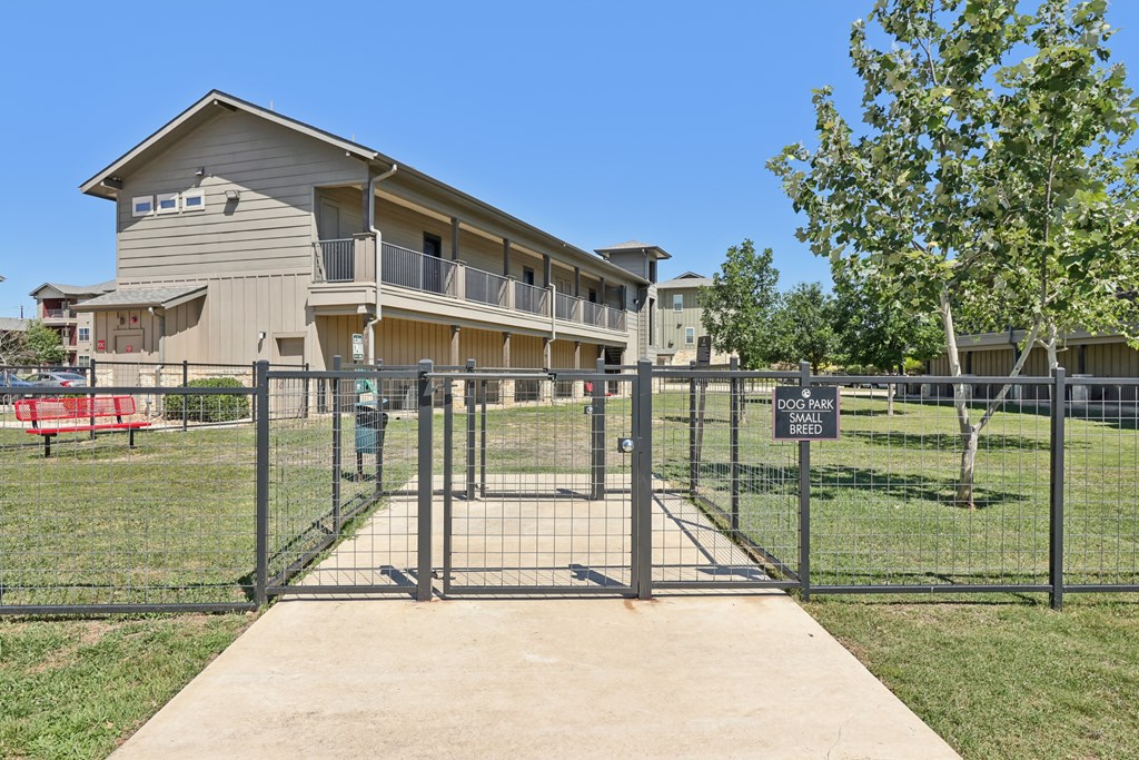 A gated entrance to a building with a sign on the fence.