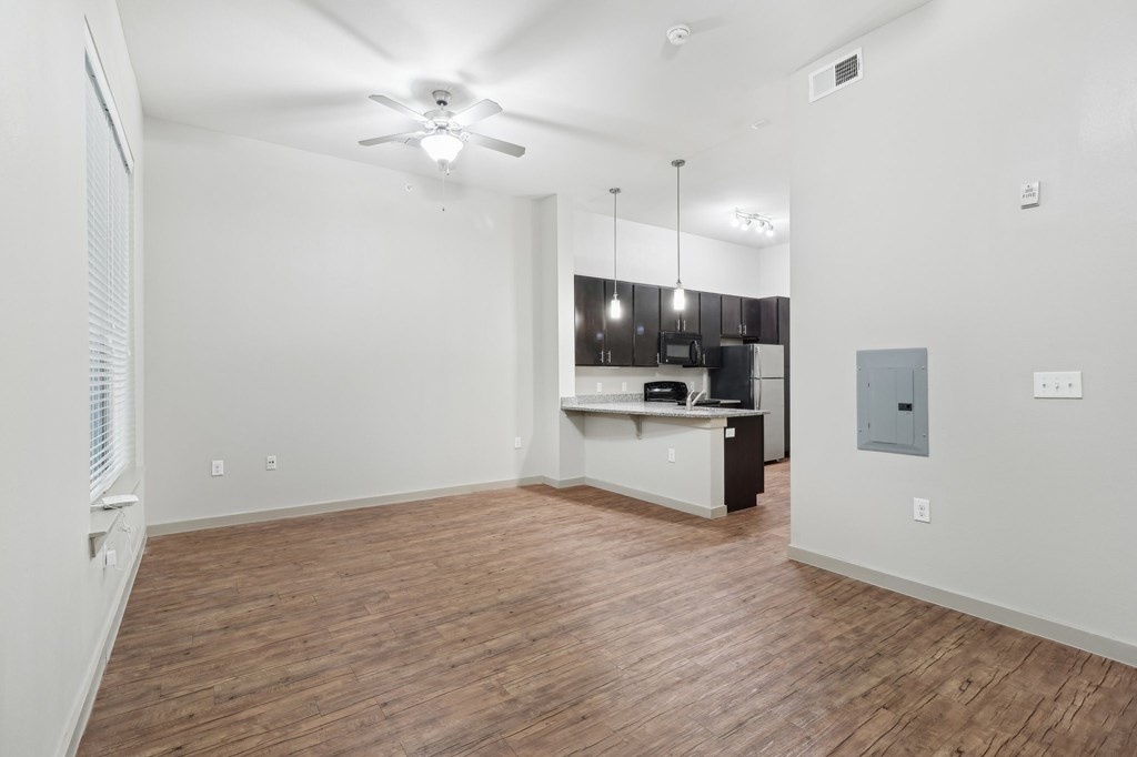 A room with a ceiling fan and wooden flooring.