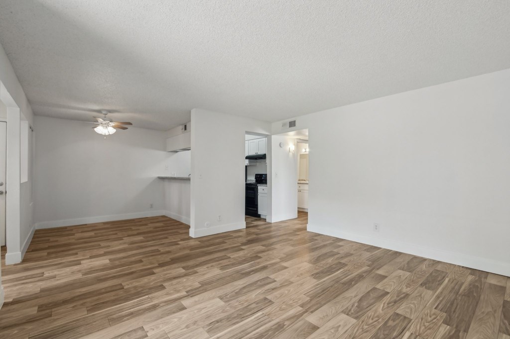 A room with wooden flooring and white walls at Candela Park Apartments, Mesa