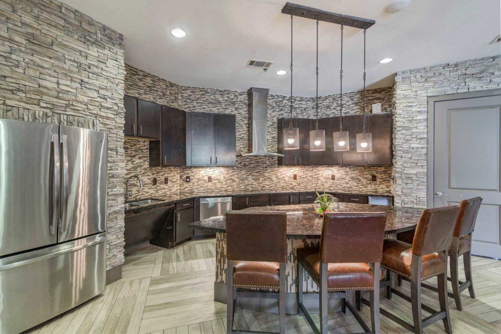 a kitchen with a island and a stainless steel refrigerator