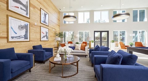 a living room with blue couches and chairs and a table