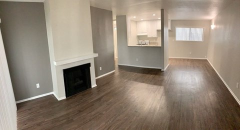 a living room with wood floors and a fireplace
