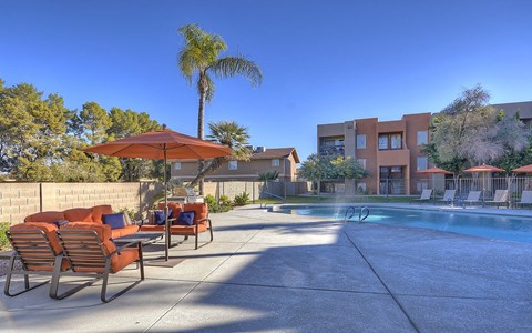 a swimming pool with chairs and umbrellas at the resort