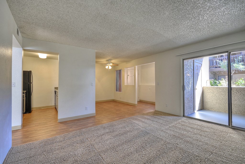 spacious living room with a sliding glass door to a patio and view of the kitchen