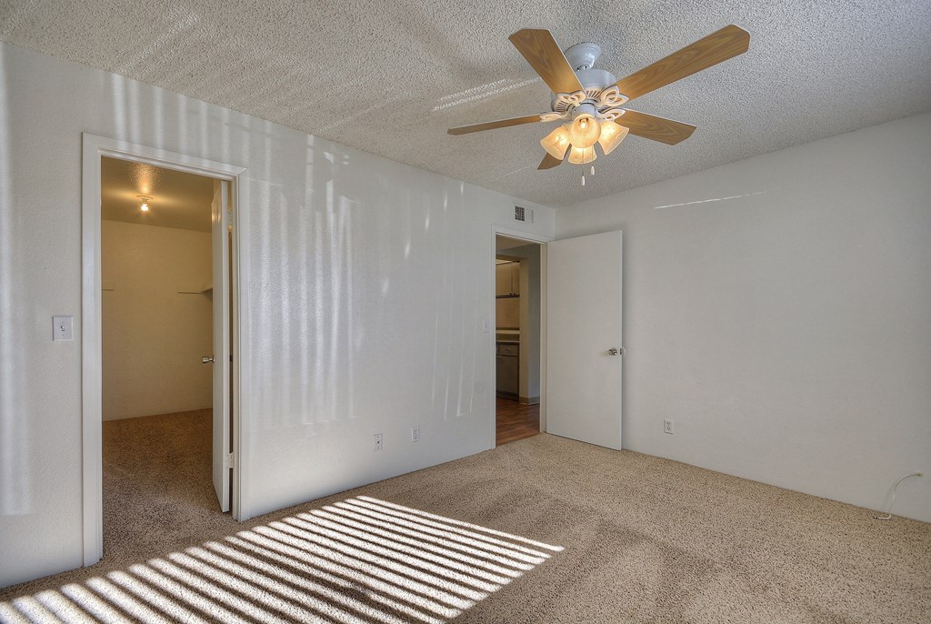 open bedroom are and ceiling fan
