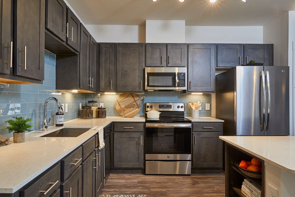 Upgraded Kitchen with Gray Cabinets, Stainless Steel Appliances, Kitchen Island, Backsplash at Addison Medical Center Apartments, San Antonio, 78229