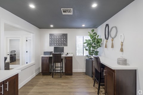 A kitchen with a white counter top and wooden floors.