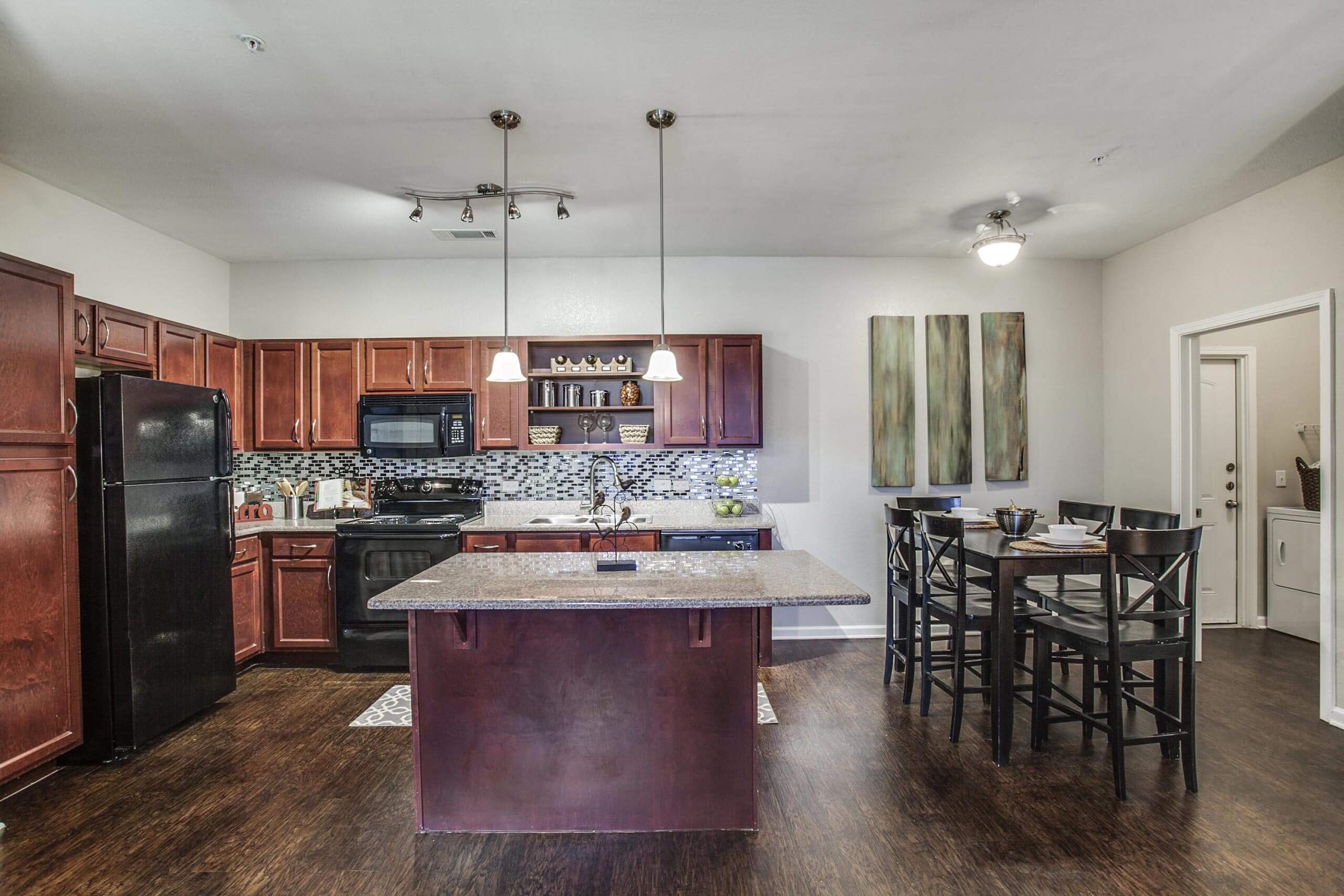 a kitchen with a large island and a table with chairs