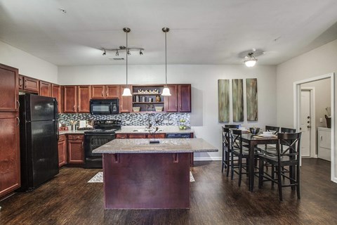 a kitchen with a large island and a table with chairs