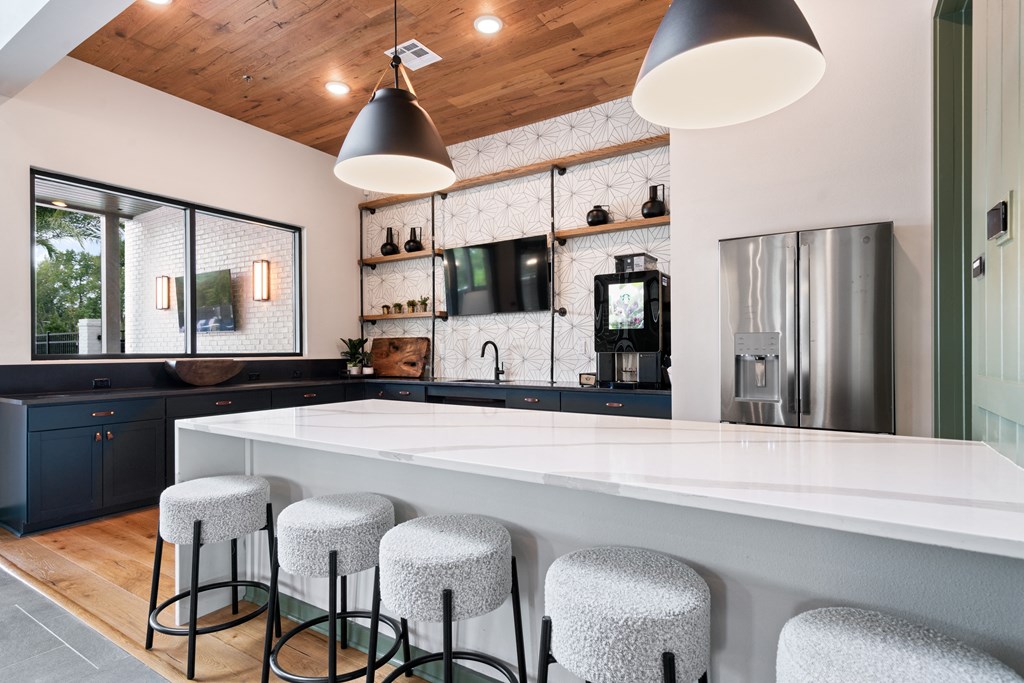 a Clubhouse kitchen with a large white counter top and bar stools