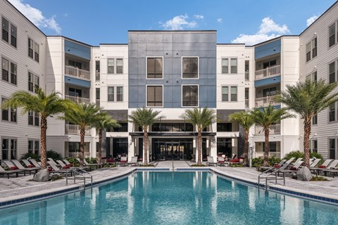 A large building with a pool in front of it. at CODA Apartments , Orlando, FL, 32826