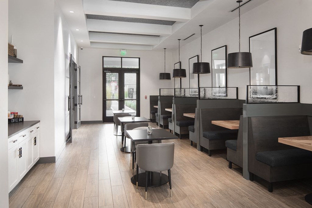 a clubhouse with tables and chairs and a bar with chairs