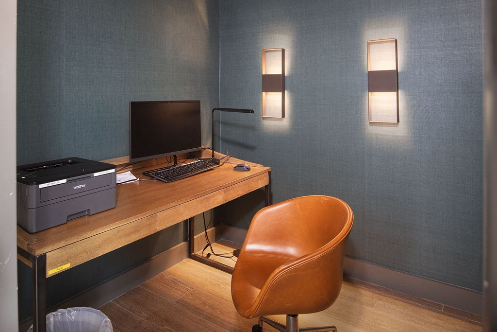 a desk with a computer and a chair