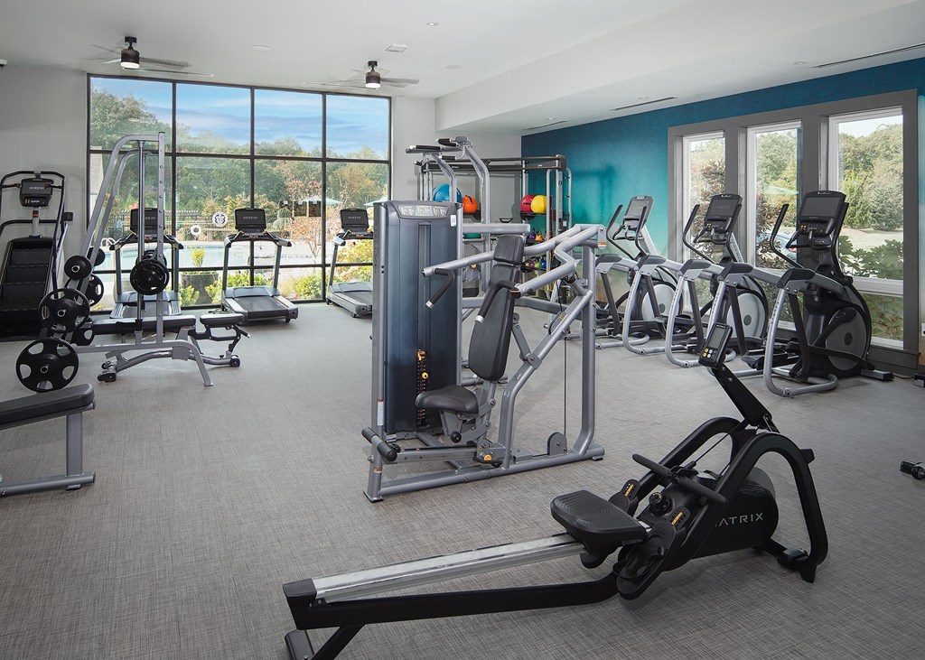 a gym with exercise equipment and windows in a building