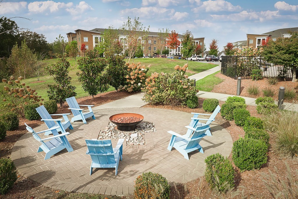 an outdoor patio with blue chairs and a fire pit