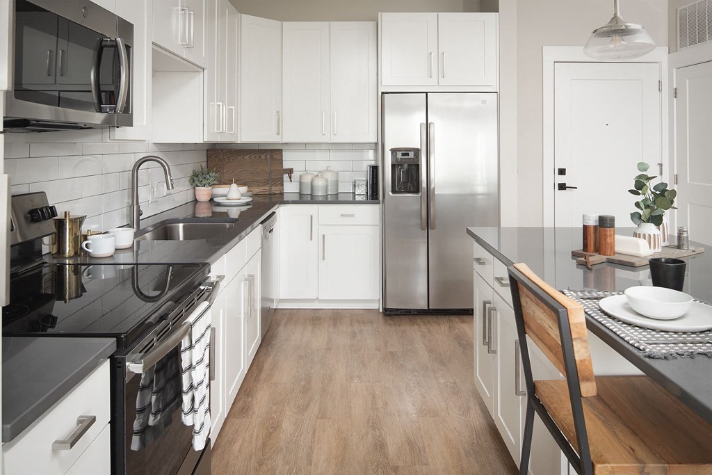 a kitchen with white cabinets and a stainless steel refrigerator
