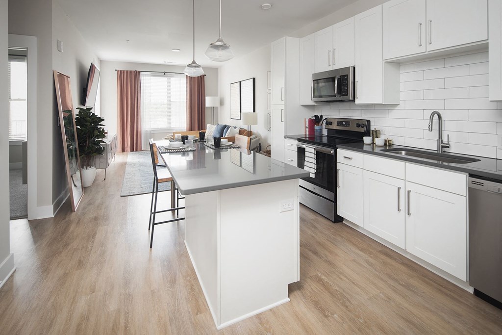 a white kitchen with a large island in the middle