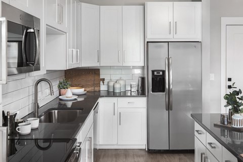 a kitchen with white cabinets and a stainless steel refrigerator