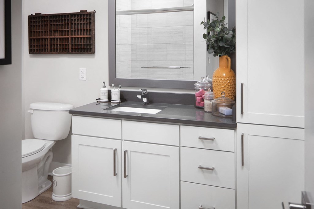 a white bathroom with a sink and a window