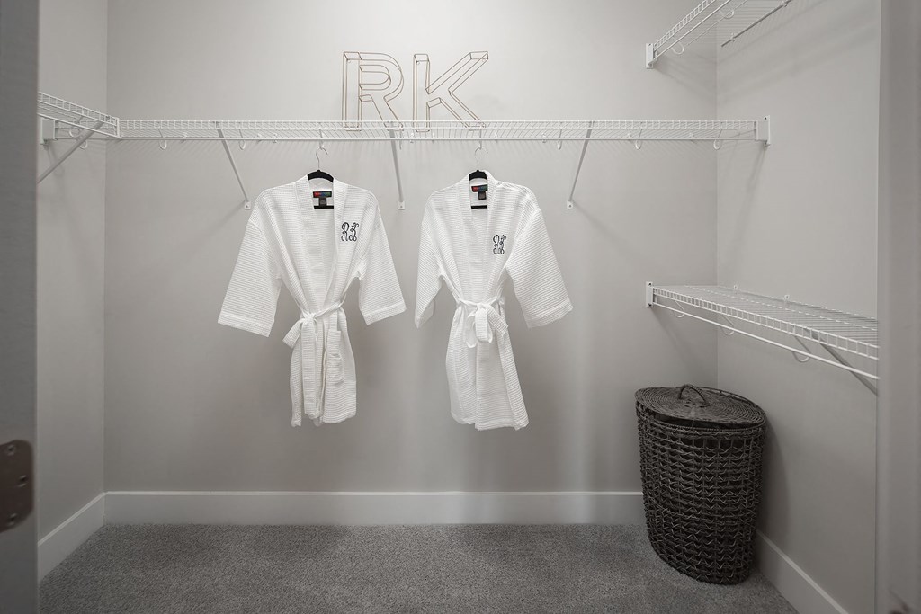 two white robes hanging in a walk-in closet