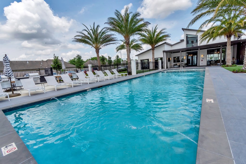 A large swimming pool with a staircase leading to a house.