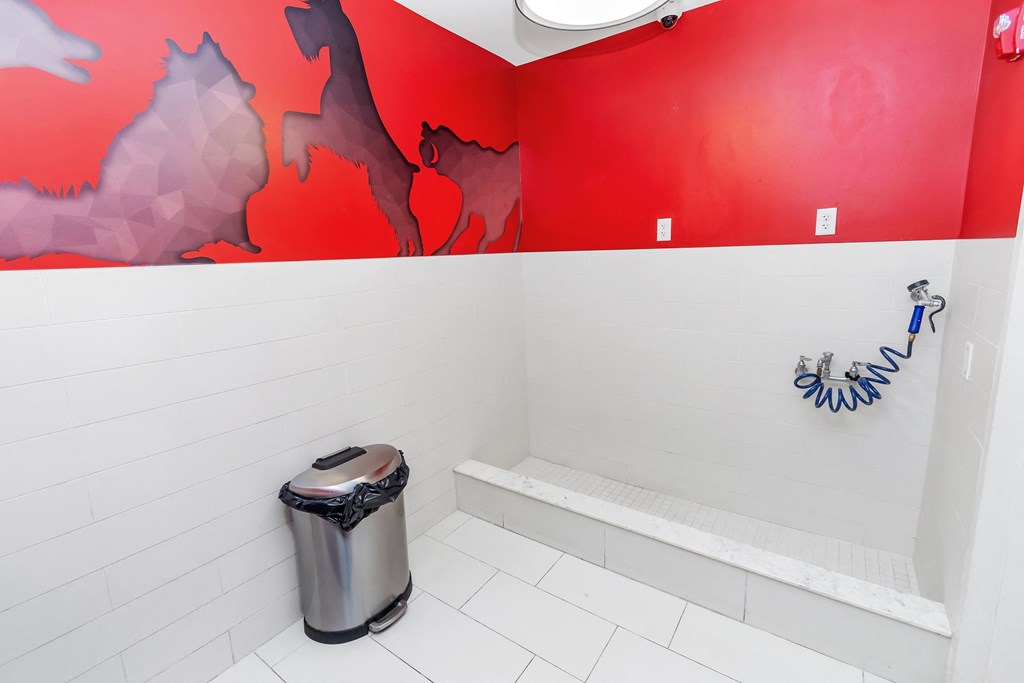 a bathroom with a red and white wall and a white tile floor