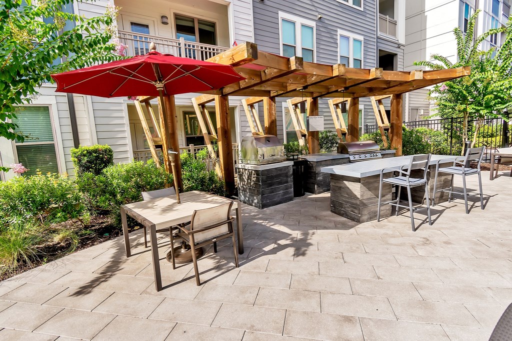 a patio with a fire pit and a pergola