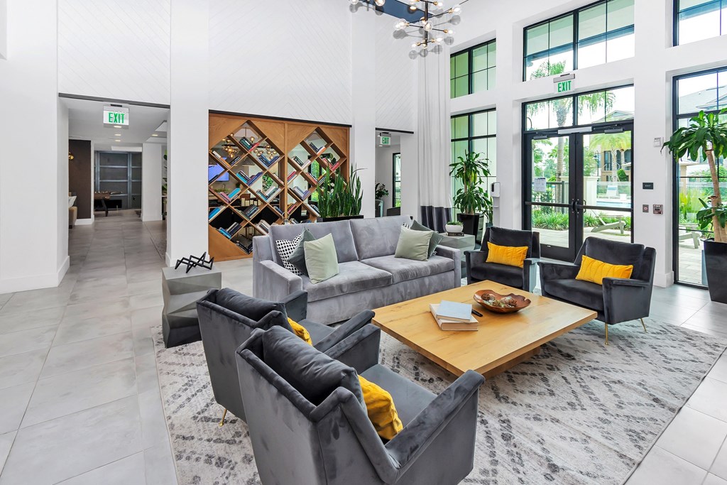 a clubhouse living room filled with furniture and a large window