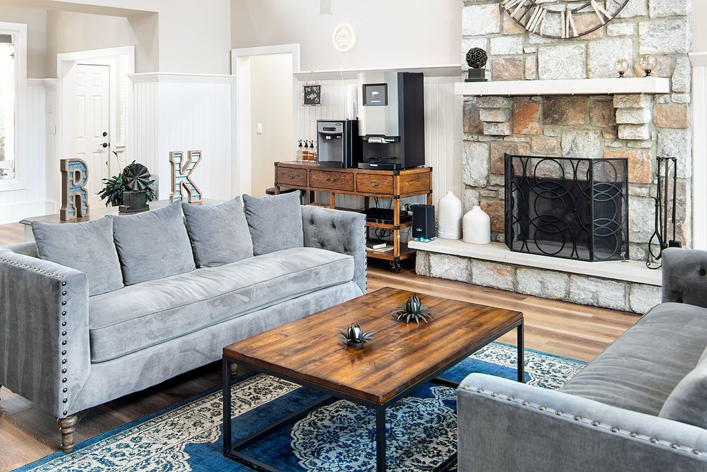 A grey couch sits in a living room with a wooden coffee table in front of it.