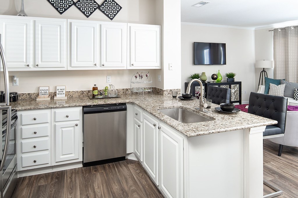 A kitchen with white cabinets and a dishwasher.
