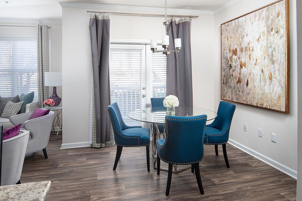 A dining room with a table and blue chairs.