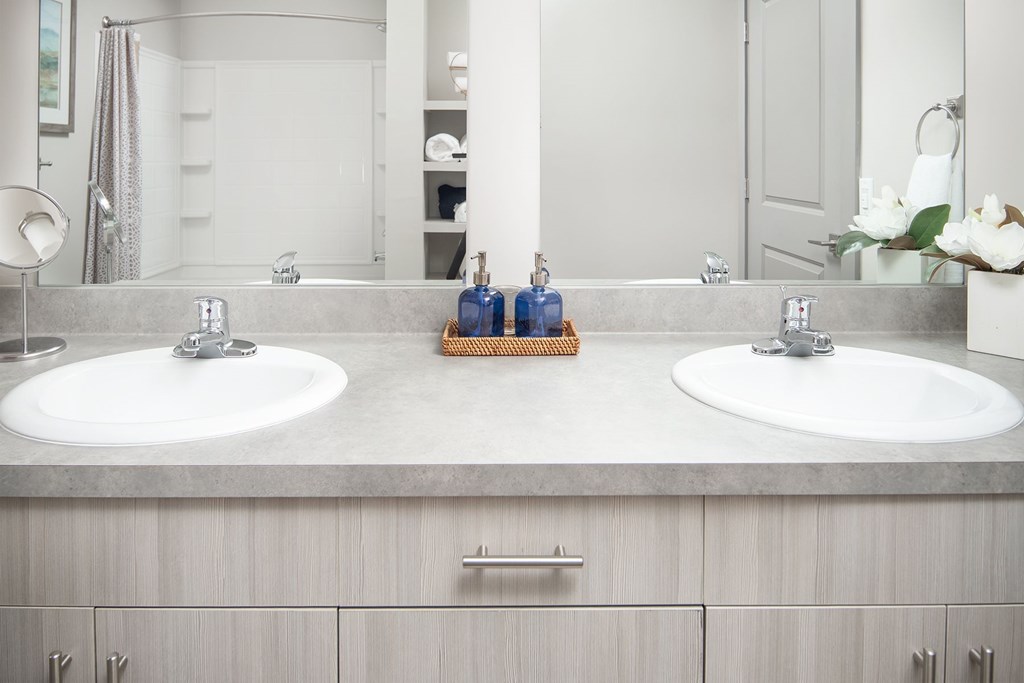 A bathroom with two sinks and a mirror.