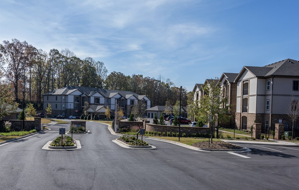 A residential street with houses on both sides and a clear blue sky.