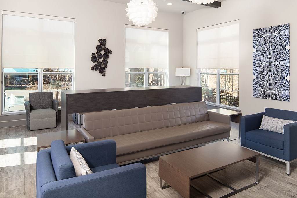 A room with a brown couch, blue armchair, and a wooden coffee table.