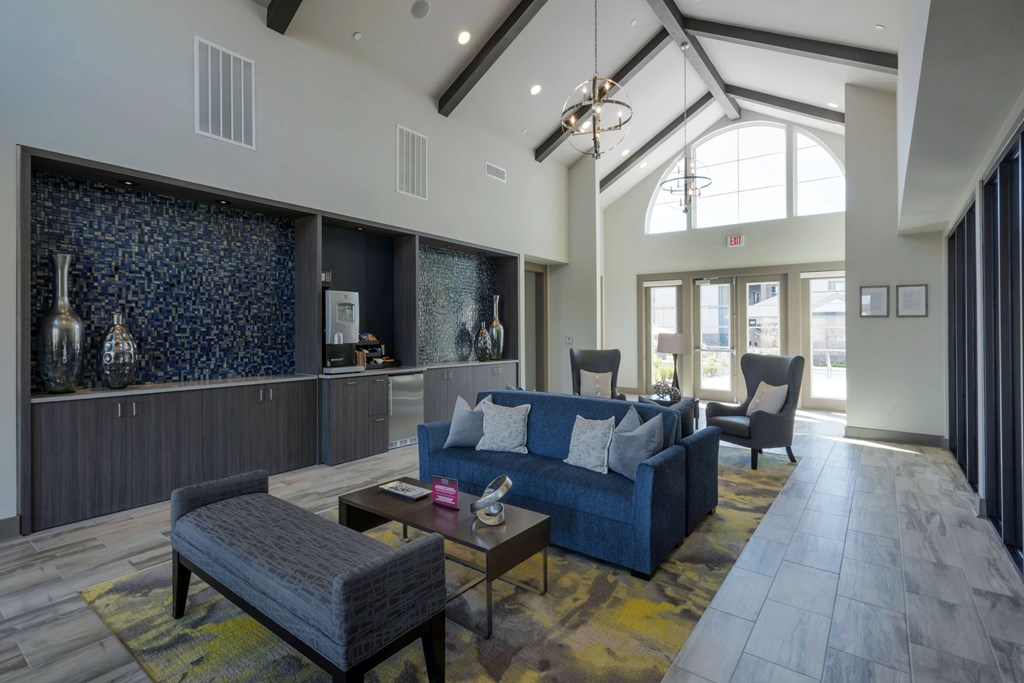 A modern living room with a blue couch and a glass wall.