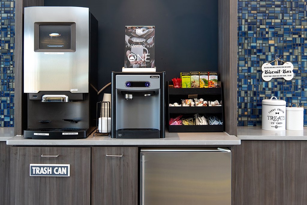 A counter with a trash can, a vending machine, and a snack bar.