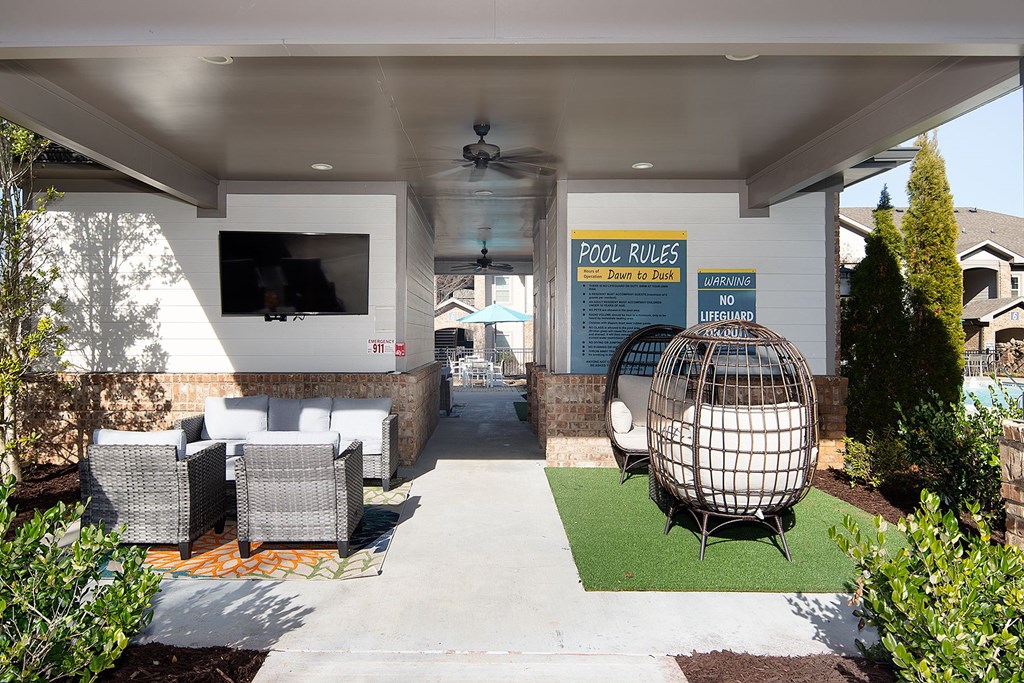 A pool area with a sign that says "POOL RULES".