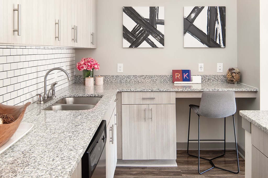 A kitchen with a granite counter top and a sink.