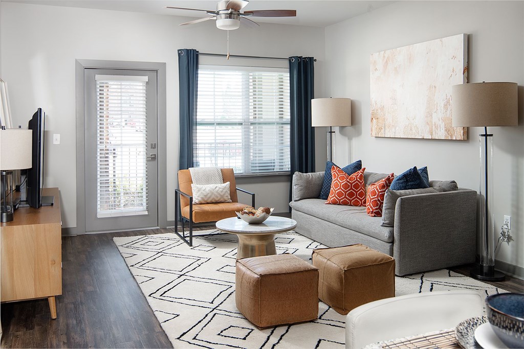 A living room with a grey couch, a brown chair, and a white coffee table.