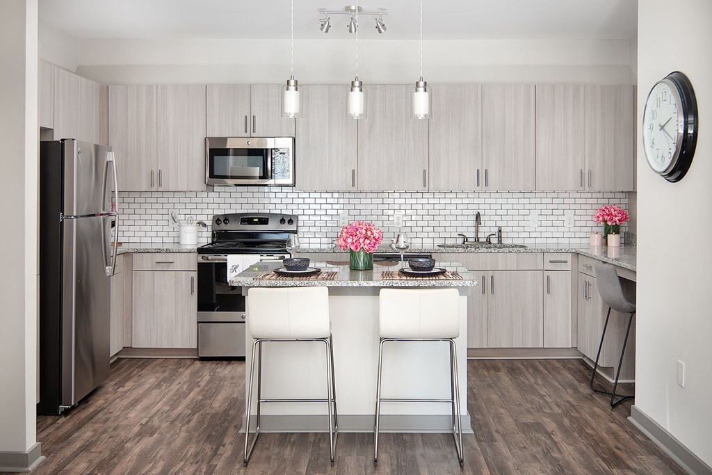 A kitchen with chairs in the middle of the room.